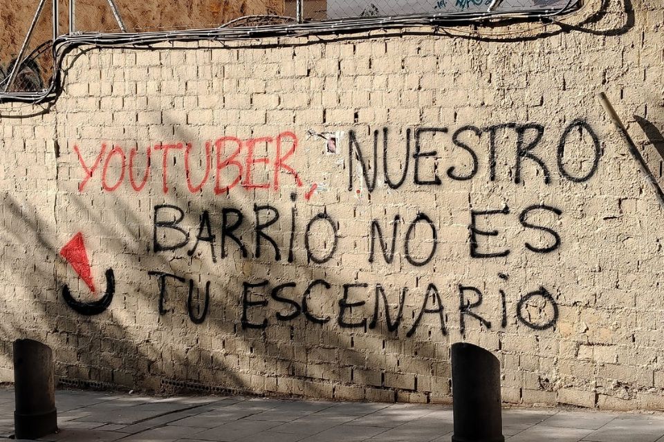 Graffiti in Madrid saying "youtuber, nuestro barrio no es tu escenario"