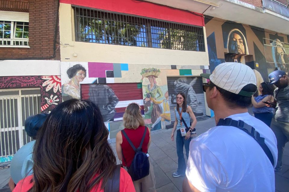 guide in front of a mural in lavapiés taking with a group
