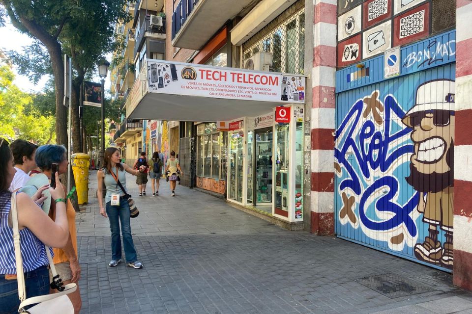 People looking at a piece from street artist Reos