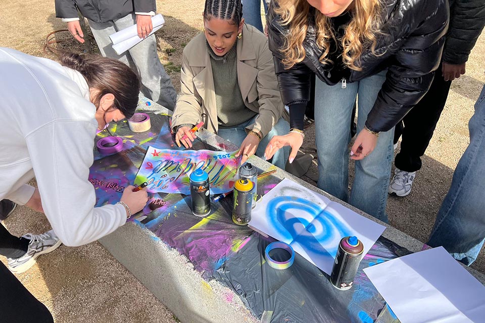 Teenagers painting with markers and spray cans