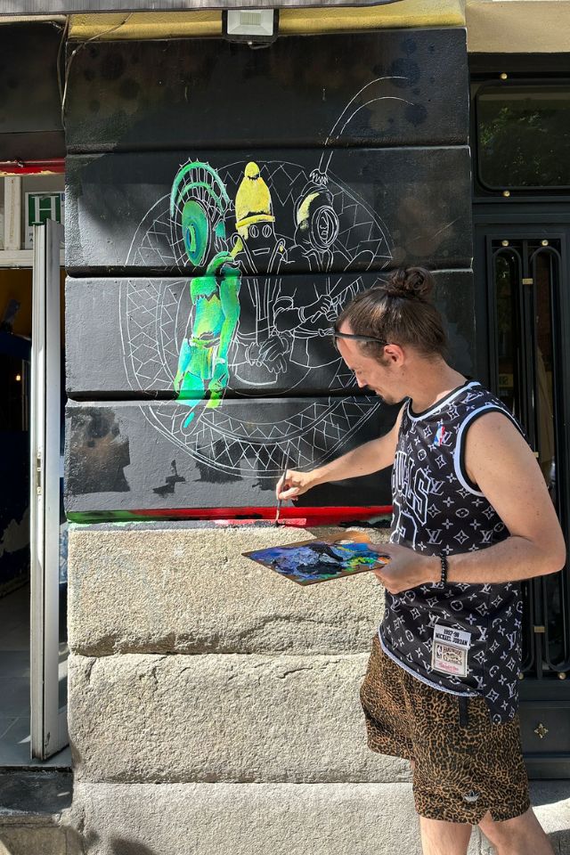 artist painting a mural during CALLE Lavapiés, a Madrid street art festival