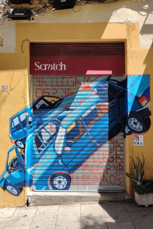 Mural painted on shutters and walls of a blue car