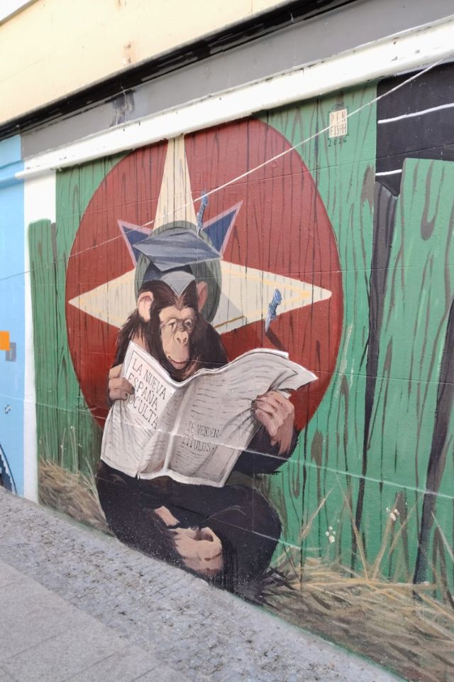 mural with a monkey reading a newspaper in malasaña, another Madrid street art festival 